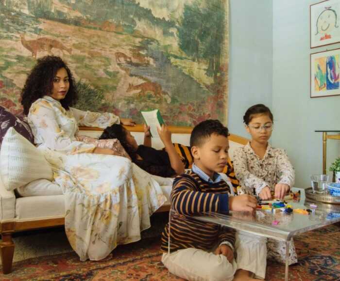 a woman in a long dress enjoys time with her children in a well-designed room