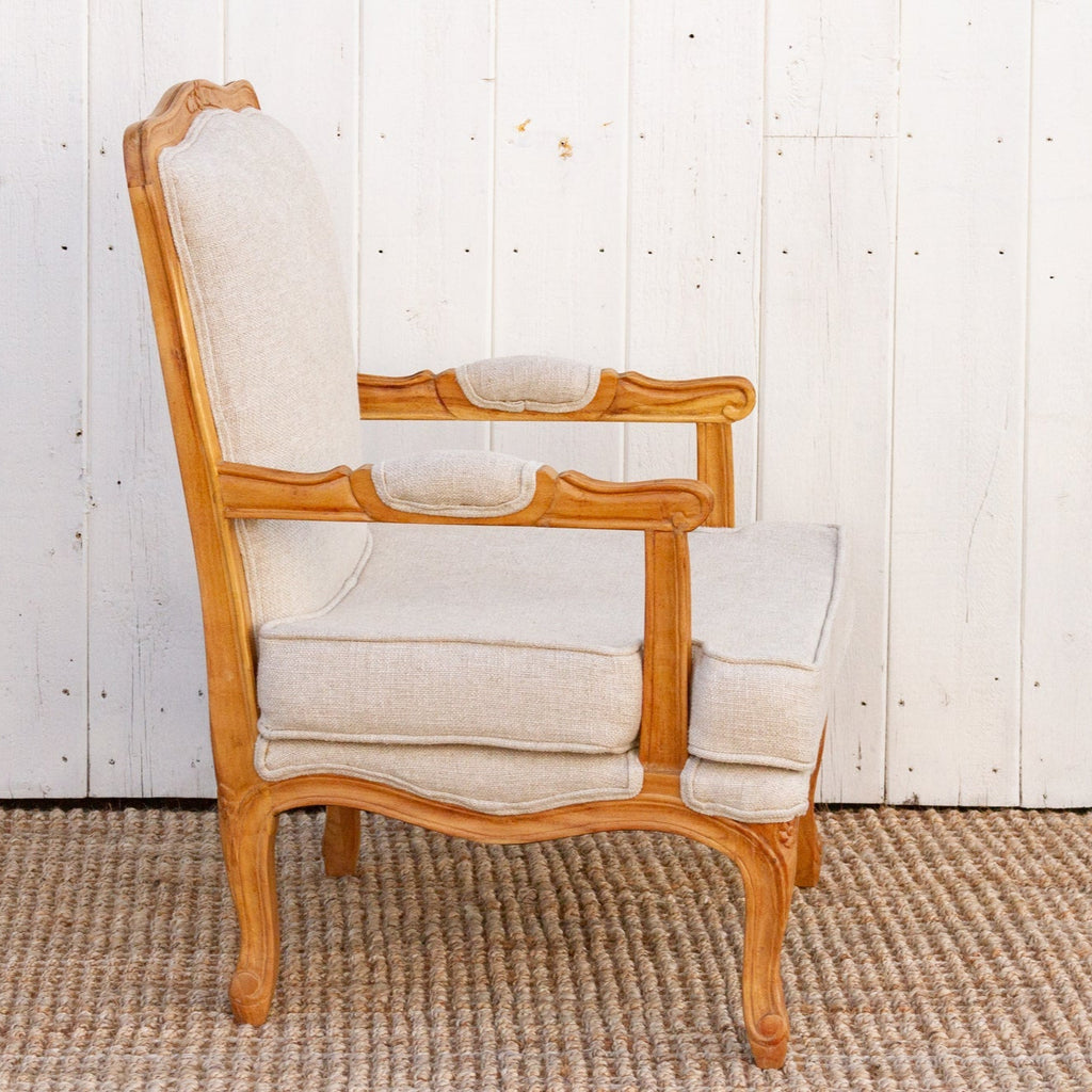 Wooden armchair with white cushions against a white wooden panel background